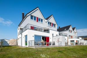 a large white house with a lawn in front of it at SEAesta in Olpenitz