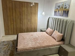 a bedroom with a large bed with two pillows on it at Apprt lux in Oujda