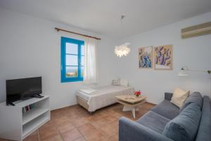ein Wohnzimmer mit einem Sofa und einem TV in der Unterkunft Eleni Villas in Hersonissos