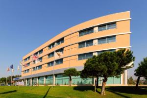 a building with flags in front of it at TRYP by Wyndham Porto Expo Hotel in Leça da Palmeira