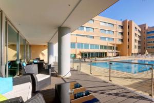 an image of a hotel patio with a swimming pool at TRYP by Wyndham Porto Expo Hotel in Leça da Palmeira