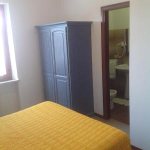 um quarto com uma cama, um armário e uma casa de banho em Il Sentiero em Ostra Vetere
