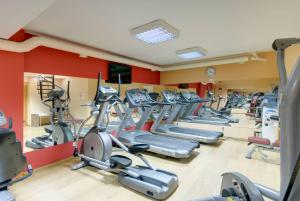 a gym with rows of treadmills and elliptical machines at TRYP by Wyndham Porto Expo Hotel in Leça da Palmeira