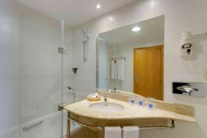 a bathroom with a sink and a mirror at TRYP by Wyndham Porto Expo Hotel in Leça da Palmeira