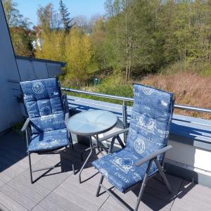 Dos sillas y una mesa en una terraza. en Ferienwohnung Meeresrauschen, en Graal-Müritz