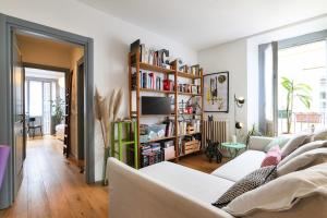 a living room with white furniture and a book shelf at PrimoPiano - Arnolfo in Milan