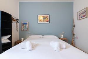 a bedroom with a white bed with white towels on it at PrimoPiano - Arnolfo in Milan