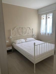 sypialnia z białym łóżkiem i 2 oknami w obiekcie A due passi sul mare w mieście San Pietro in Bevagna