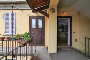 a house with a brown door and a balcony at PrimoPiano - Arnolfo in Milan