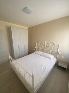 sypialnia z białym łóżkiem w pokoju w obiekcie A due passi sul mare w mieście San Pietro in Bevagna