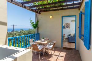 Un patio con una mesa y sillas en un balcón. en Eleni Villas, en Hersonissos