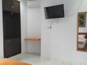 Zimmer mit einem Flachbild-TV an der Wand in der Unterkunft C4 homestay in Jakarta