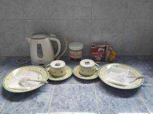 a table with four plates and a tea kettle at C4 homestay syariah in Jakarta