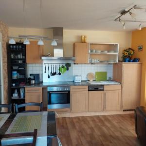 a large kitchen with wooden cabinets and a table in it at Ferienwohnung Meeresrauschen in Graal-Müritz +29 photos