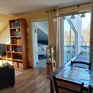 Una sala de estar con una mesa y un dormitorio. en Ferienwohnung Meeresrauschen, en Graal-Müritz 29 fotos más