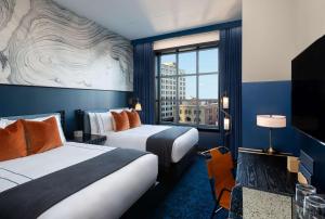a hotel room with two beds and a large window at Dream Nashville, by Hyatt in Nashville