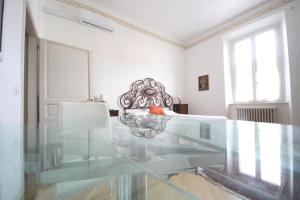 AMAMARE في مارينا دي بيزا: طاولة زجاجية في غرفة بيضاء مع طاولة زجاجية