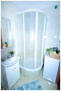 a white bathroom with a shower and a sink at Color24 Apartament VI in Stalowa Wola