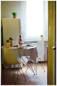 Color24 Apartament VI في ستالوفا فولا: طاولة طعام مع كراسي وثلاجة