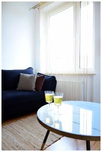 a living room with a glass table and two glasses of wine at Color24 Apartament VI in Stalowa Wola