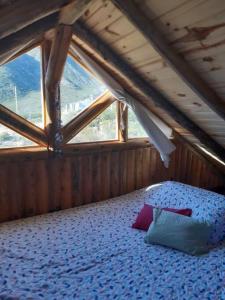 1 dormitorio con 1 cama en un ático con ventana en Los Cardones Tiny House en Potrerillos
