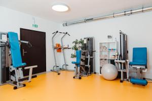 a gym with blue chairs and equipment in a room at Hotel Das Grambacher 