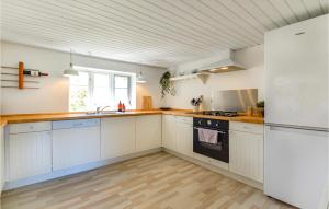 La cuisine est équipée de placards blancs et d'un réfrigérateur blanc. dans l'établissement Gorgeous Home In Ask With Kitchen, 