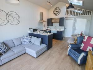 a living room with a couch and a kitchen at Little Shelve Barn in Shrewsbury +13 photos