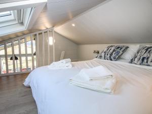 a bedroom with a white bed with towels on it at Little Shelve Barn in Shrewsbury