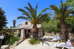 een huis met twee palmbomen ervoor bij Salento d a mare in Torre Pali 