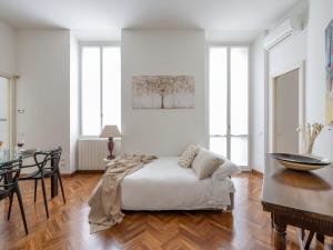 a white bedroom with a bed and a table at The Best Rent - Gorgeous two-bedroom apartment in Porta Nuova district in Milan