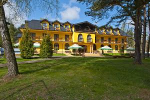 a large yellow building with umbrellas in a park at Ośrodek Zacisze in Rozewie