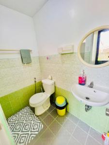 a bathroom with a toilet and a sink at Awesome 2 bedrooms, living & dining area in General Trias