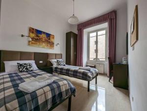 a bedroom with two beds and a window at Francesco Romestay - Termini in Rome