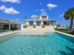 a villa with a swimming pool in front of a house at Belvilla by OYO La Sirena in Carrer del Mar