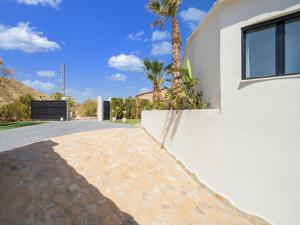 a driveway of a house with a palm tree at Belvilla by OYO La Sirena in Carrer del Mar