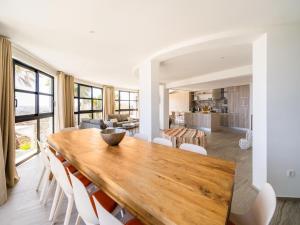 a kitchen and dining room with a wooden table and chairs at Belvilla by OYO La Sirena in Carrer del Mar