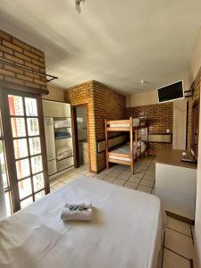 Zimmer mit einem Bett und einer Küche mit einem Kühlschrank. in der Unterkunft Hotel D'Luz in Itapema