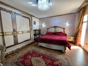 a bedroom with a bed with a red comforter at شقه سكنيه فى مدينتى in Madinaty