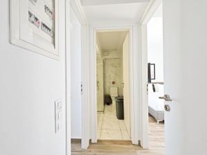 a hallway leading to a bathroom with a toilet at Nemeseos Apartments by Verde in Athens