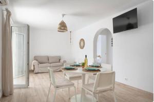 een witte woonkamer met een tafel en stoelen bij Aptos dOr in Cala d´Or