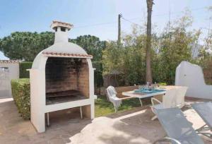 een achtertuin met een open haard en een tafel en stoelen bij Aptos dOr in Cala d´Or