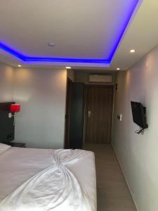 Schlafzimmer mit einem Bett mit blauem Licht an der Decke in der Unterkunft Erikli suit home in Erikli