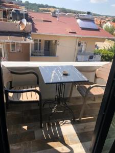 einen Tisch und Stühle auf einem Balkon mit Blick auf ein Gebäude in der Unterkunft Erikli suit home in Erikli
