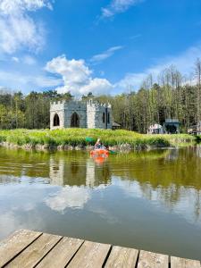 a person kayaking on a river in front of a castle at Ironland Roztocze 