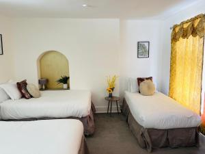 two beds in a room with white walls and yellow curtains at Big Group Stays in Brighton & Hove