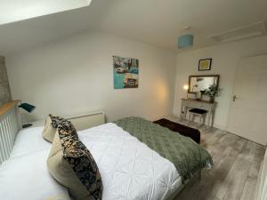 a bedroom with a bed and a mirror on the wall at Rosebank Apartment no 3 in Moville