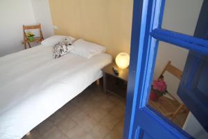 a small bedroom with a white bed and a blue door at Apartament - COMPARTIR in Cadaqués
