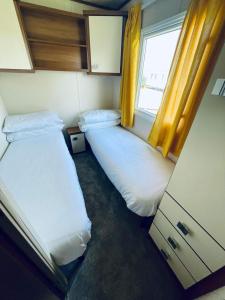 Superb Caravan At Steeple Bay Holiday Park In Essex, Sleeps 6 Ref 36081d tesisinde bir odada yatak veya yataklar