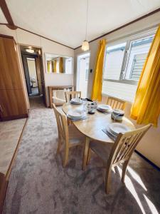 a dining room with a wooden table and chairs at Superb Caravan At Steeple Bay Holiday Park In Essex, Sleeps 6 Ref 36081d in Southminster